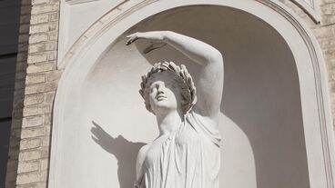 Cherry picking paradise Statue mit Arm über Kopf, Lorbeerkranz, weißer Mamor,Schatten, Sonne, weißer Bogen