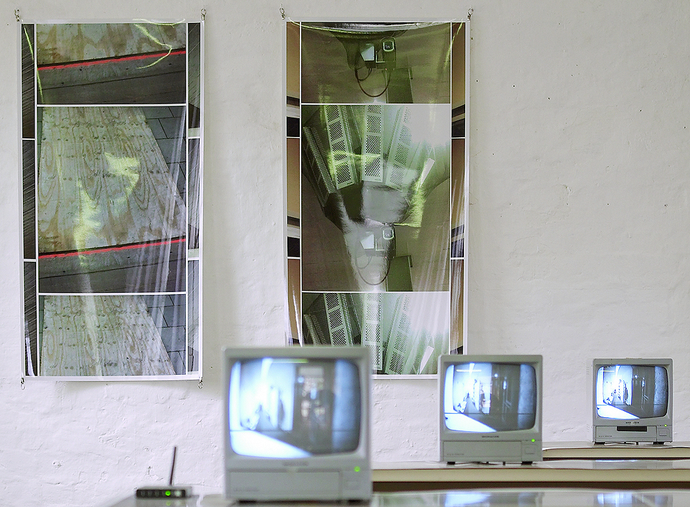 a view showing two wall photos and three video monitors