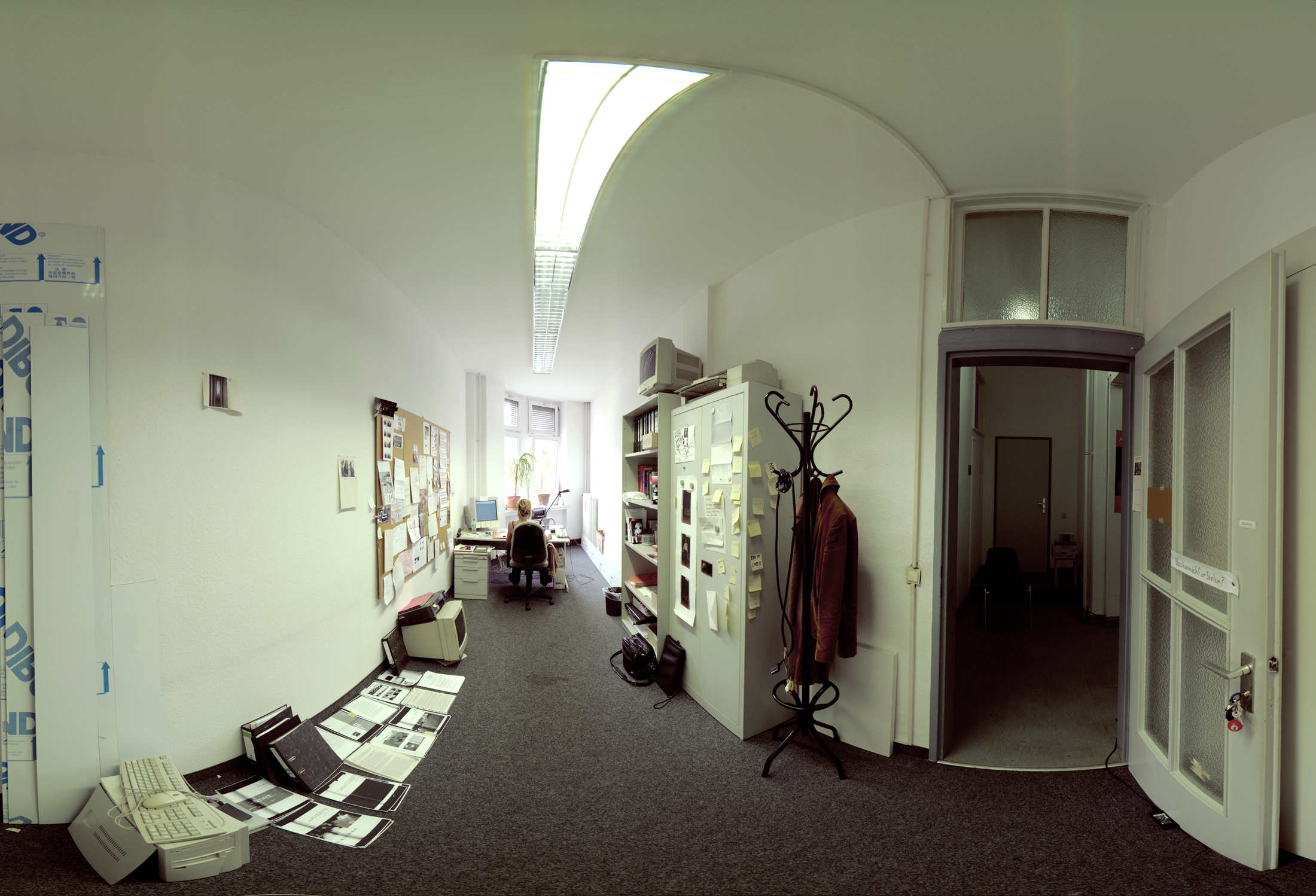 a wide angle view of the artist Susanna Schoenberg working in her office room