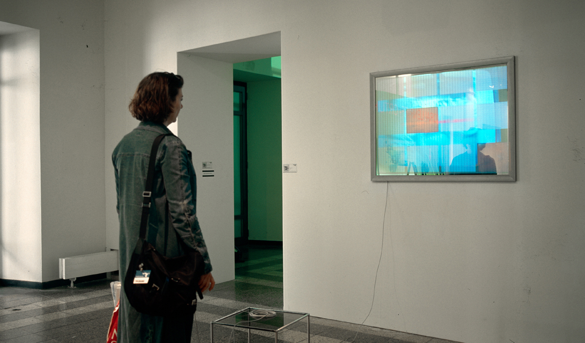a female visitor watching the video installation screen