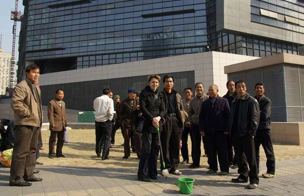 the artist Susanna Schoenberg amongst a group of chinese men in a break of her public performance/experiment